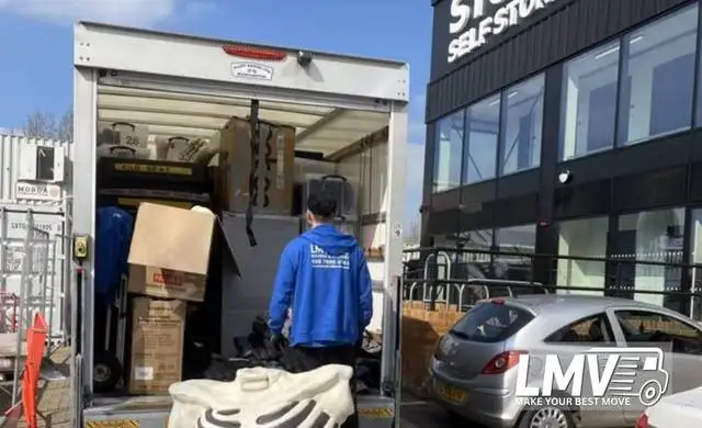 Movers loading furniture and boxes into van for storage removals in South East London