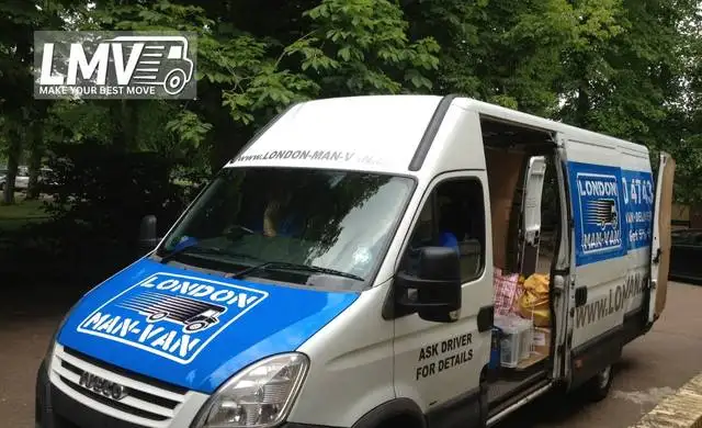 Movers loading furniture and home appliances into a van for delivery in South West London